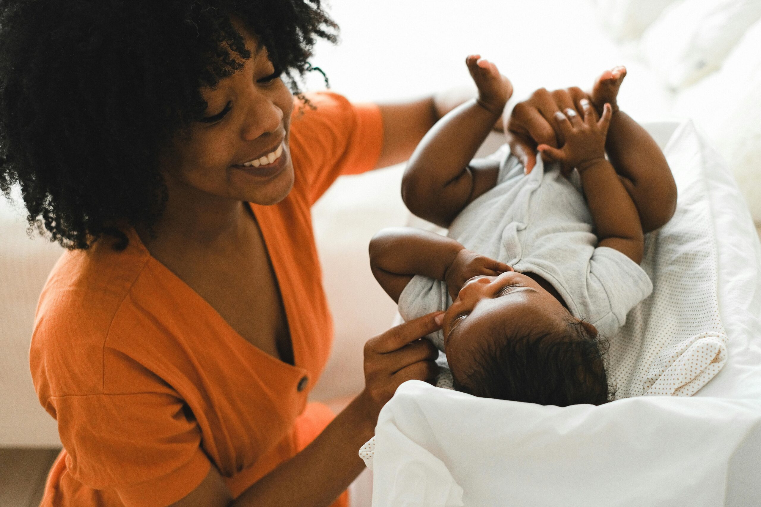 Postnatal care nurse supporting a new mother and her baby at home